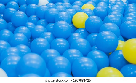 Close up of plastic yellow and blue balls at the playground. Soft focus. Background.