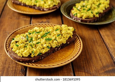 Close Up Of A Plate With Bright Yellow Vegan Egg Salad Sandwiches