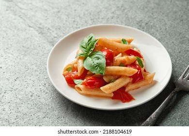 Close Up Plate Of Penne Pasta With Fried Cherry Tomatoes On Gray Slate Background High Angle View Studio Shot