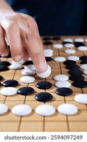 close up of player hand make a move in Go game(Weiqi),Traditional trategy board game