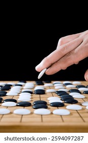 close up of player hand make a move in Go game(Weiqi),Traditional trategy board game