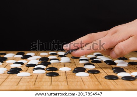 close up of player hand make a move in Go game(Weiqi),Traditional asian strategy board game