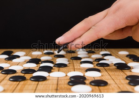 close up of player hand make a move in Go game(Weiqi),Traditional asian strategy board game