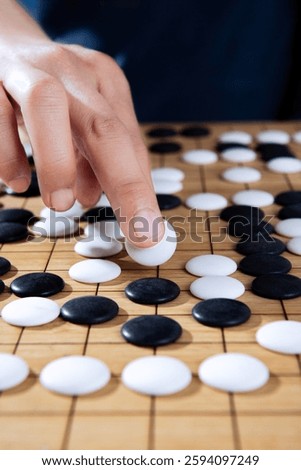 close up of player hand make a move in Go game(Weiqi),Traditional trategy board game
