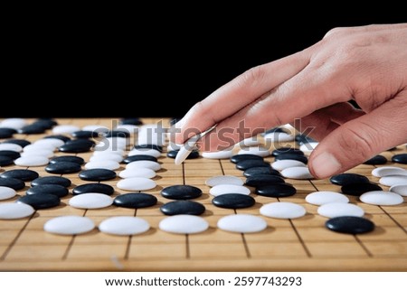 close up of player hand make a move in Go game(Weiqi),Traditional trategy board game