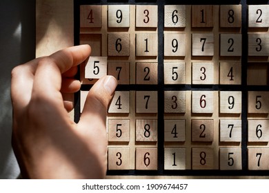 Close up of playing a wood Sudoku game board with puzzle in progress