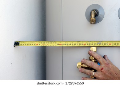 A Close Up Of A Plumber Installing An Electrical Hot Water Cylinder. 