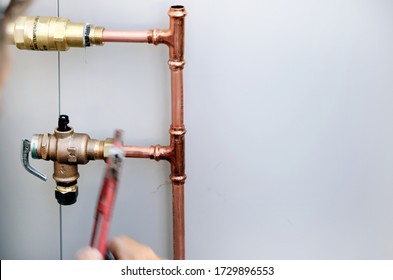 A Close Up Of A Plumber Installing An Electrical Hot Water Cylinder. 