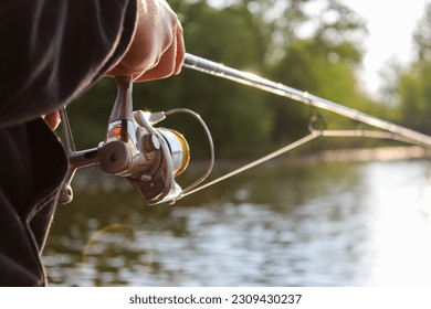 close up pole, man fishing while sun is setting on the lake. - Powered by Shutterstock