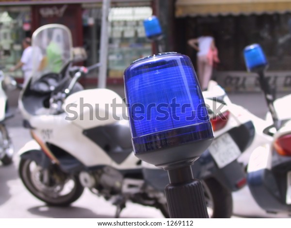 close up of a police light with a police\
motorcycle in the\
background