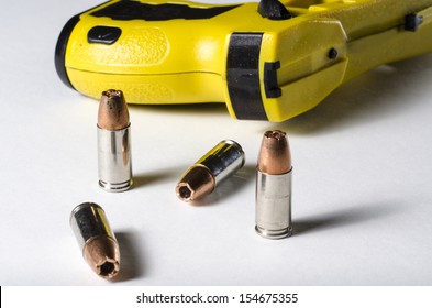 A Close Up Of A Police Stun Gun And Bullets.