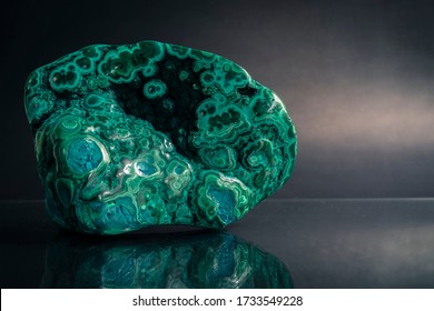 Close up polished malachite and chrysocolla with green and blue texture, on dark background. Chrysocolla is thought to have gentle balancing energy while Malachite is soothing to the soul.