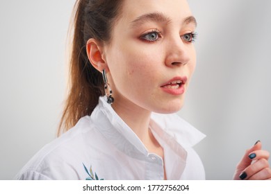 Close Up Portrait Of 20-25 Years Old Girl In A White Blouse. Beautiful Girl With A Tail Posing And Not Looking At The Camera