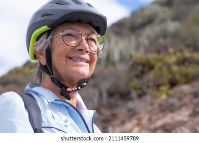 Close Up Portrait Of Active Adult Smiling Senior Woman Wearing Sport Helmet And Eyeglasses In Outdoors Excursion. Happy Attractive Elderly Female Enjoying Healthy Lifestyle And Nature