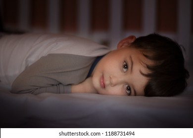 close up portrait of adorable boy lying in the crib and looking at the camera - Shutterstock ID 1188731494