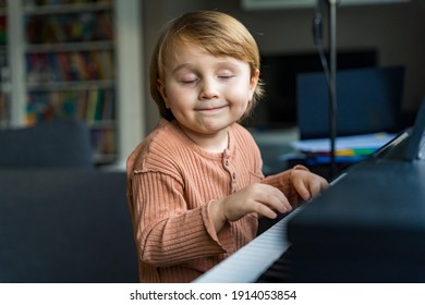 Close Up Portrait Of Adorable Little Toddler Boy. Smiling Child Playing Piano At Home. Kid Learning  Play Music. Early Development.