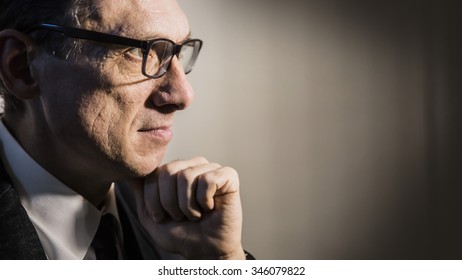 Close Portrait Of An Adult Man In Profile Thinking In A Dark Room