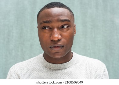 Close up portrait African American man glancing by green background