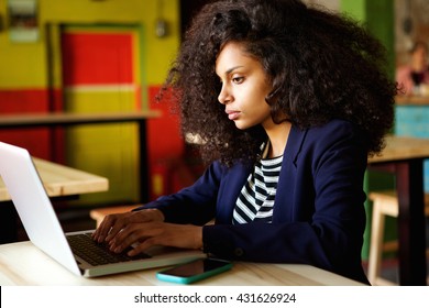 Close Up Portrait Of African Woman Using Laptop At Coffee Shop