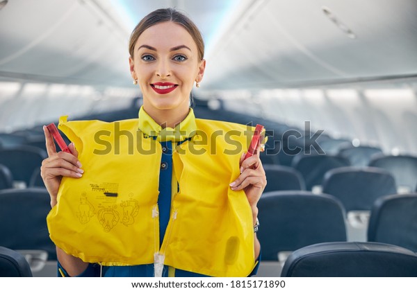 Close up portrait of\
air hostess demonstrating safety procedures to passengers prior to\
flight take off