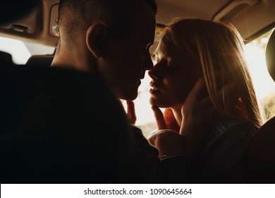 Close up portrait of a amazing young couple sitting in their car face to face waiting to kiss, with closed eyes and smiling.