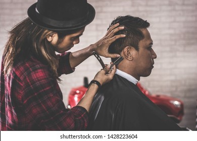 Close Up Portrait Of Asian Barber With Long Hair Shaving His Costumer Hair At Barbershop Chair