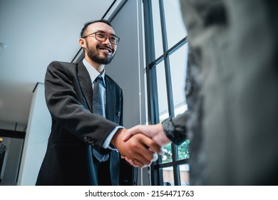 Close Up Portrait Of Asian Businessmen Shaking Hands And Smiling Shot From Below