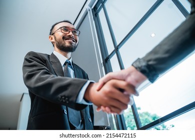 Close Up Portrait Of Asian Businessmen Shaking Hands And Smiling Shot From Below