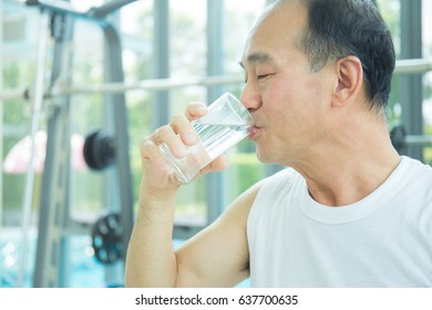 Close Up Portrait Of Asian Senior Man Drinking Glass Of Water.