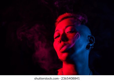 Close up portrait of asian woman with short hair smoking in neon light.  - Shutterstock ID 2365408841