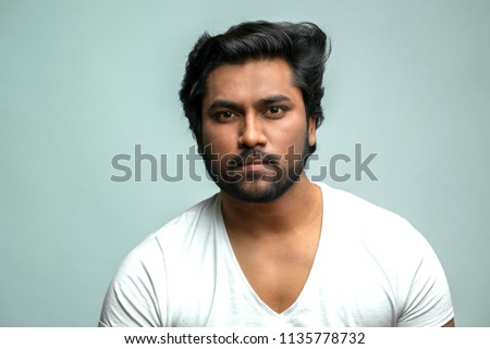 close up portrait of attractive Indian man with serious face concentrated on his job. gorgeous hindoo actor