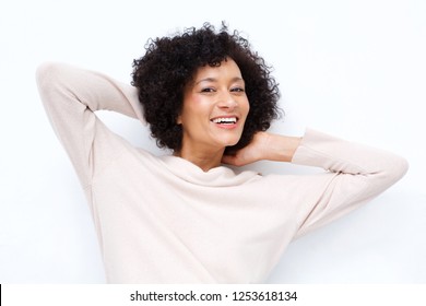 Close Up Portrait Of Attractive Middle Age African American Woman Smiling With Hands Behind Head Against White Background