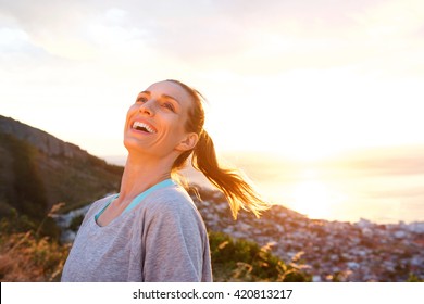 Close Up Portrait Of Attractive Older Woman Laughing Outdoors During Sunset