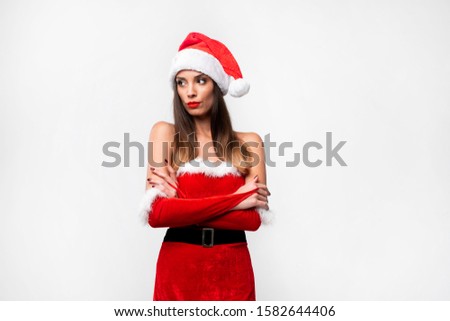 Close up portrait beautifiul caucasian woman in red Santa hat on red studio background. Christmas New Year holiday concept. Cute girlsad emotions with free copy space