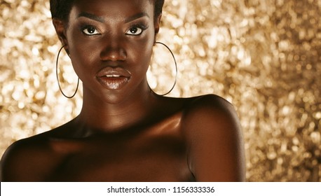 Close up portrait of beautiful african woman with creative gold make up
