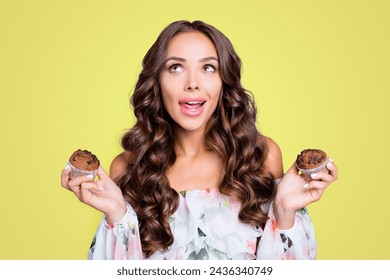 Close up portrait of beautiful, attractive, pretty, dreamy, charming curly lady people, person look aside hold muffins in hands isolated on shine teal background - Powered by Shutterstock