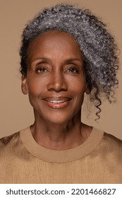 Close Up Portrait Of Beautiful Black Woman In Her Late 50s Smiling Happy With Perfect Skin And Fashionable Hairstyle On Neutral Background