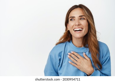 Close Up Portrait Of Beautiful Brunette Woman Laughing, Smiling And Holding Hand On Chest, Chuckle Carefree, Skin Care And Anti-aging Cosmetics Concept, White Background