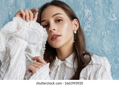 Close up portrait of beautiful fashionable woman with natural flawless skin, wearing trendy vintage style white blouse, pearl earrings. Spring, summer fashion, beauty concept - Powered by Shutterstock