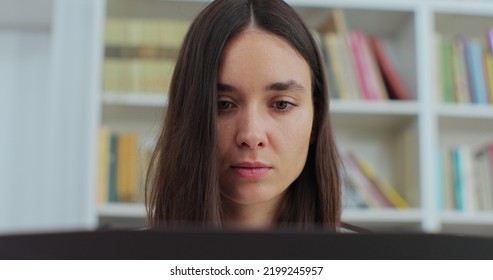 Close Up Portrait Beautiful Girl In Reading Book And Typing On Computer. College Student Works On Essay At The Library.