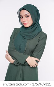Close up portrait of a beautiful Muslim female model wearing emerald green "baju kebaya" with hijab isolated over white background. Studio fashion and beauty make up concept.