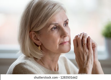Close up portrait of beautiful sad woman folding hands together near her face, thinking about life. Aging is period of physical decline and senile dementia, mental disorders emotional problems concept - Shutterstock ID 1283501662