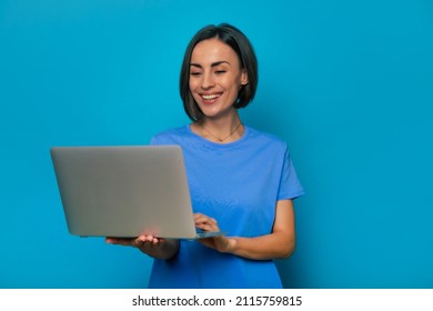 Close up portrait of beautiful smiling stylish smart woman with modern gray laptop in hands while she using it and surfing in the network for study or work - Shutterstock ID 2115759815