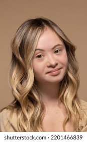 close up portrait of beautiful smiling teenage Caucasian woman with down syndrome posing on neutral background Stock Photo