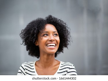 Close Up Portrait Beautiful Young African American Woman Smiling By Gray Wall And Looking Up