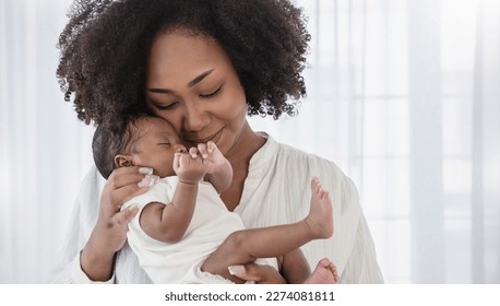 Close up portrait of beautiful young African American  mother holding sleep newborn baby in hospital bed room. Healthcare medical love black afro woman lifestyle mother's day, breast with copy space.  - Shutterstock ID 2274081811