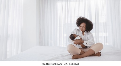 Close up portrait of beautiful young African American  mother holding sleep newborn baby in hospital bed room. Healthcare medical love black afro woman lifestyle mother's day, breast with copy space. - Powered by Shutterstock