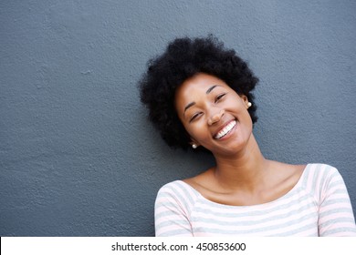 Close up portrait of a beautiful young african woman smiling against gray background