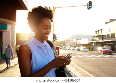 Close Up Portrait Of Beautiful Young African Woman Using Cellphone Outdoors In The City