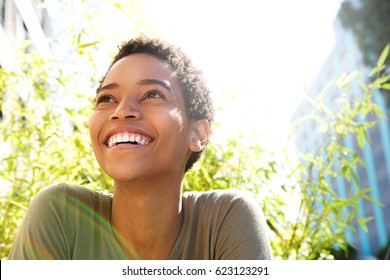 Close up portrait of beautiful young black woman smiling outdoors
